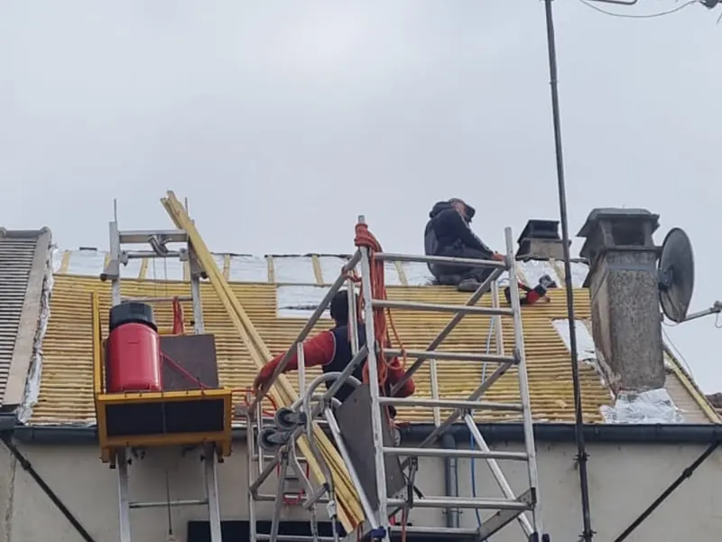 Monte-matériaux et échafaudage sur une réfection de toiture en ville